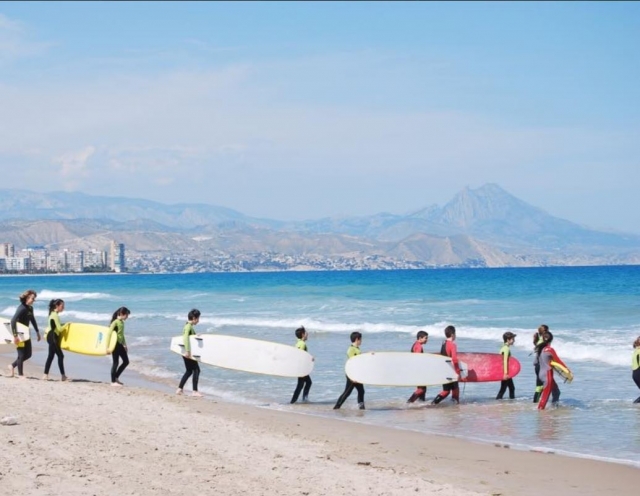 Alumnos llevando sus tablas al agua
